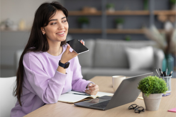 An Image of a woman using voice search on her mobile phone.